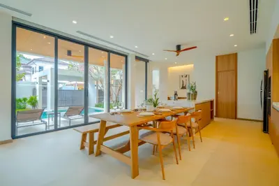 a kitchen and dining room with a wooden table and chairs at Sava Villa near Rawai in Ban Saiyuan (1)