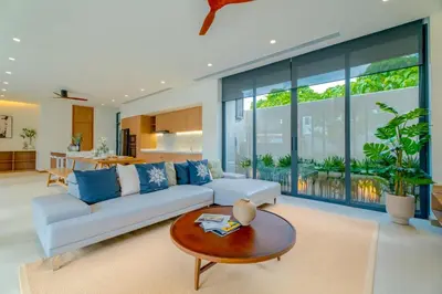 a living room with a white couch and a table at Sava Villa near Rawai in Ban Saiyuan (1)