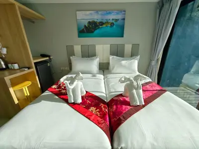 a bedroom with two beds with towels on them at The Answer Hotel in Ao Nang Beach