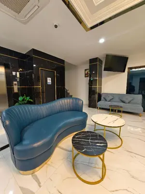 a living room with a blue couch and two tables at The Answer Hotel in Ao Nang Beach