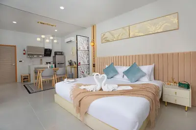 a bedroom with a large bed with swans on it at Best Time Pool Suites in Chalong