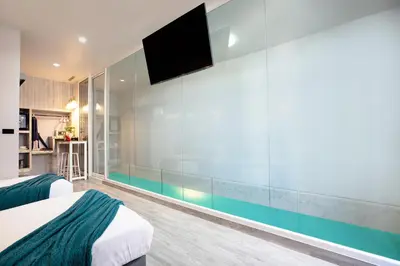 a bedroom with a large glass wall with a swimming pool at Best Time Pool Suites in Chalong