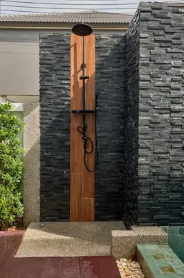 a wooden door on the side of a brick wall at Phuket Paradise Retreat in Phuket Town