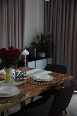 a wooden table with plates and a candle on it at Phuket Paradise Retreat in Phuket Town