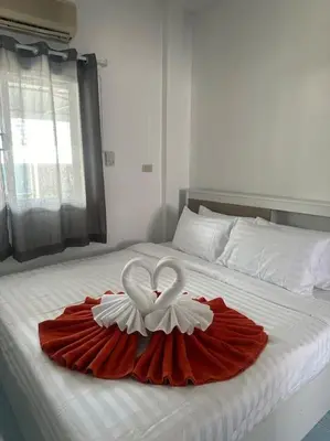 a red dress with two white swans on a bed at P&I Group Home 4 Karon beach in Karon Beach