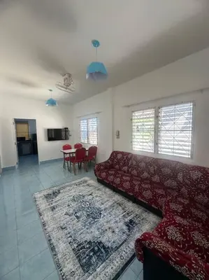 a living room with a red couch and a table at P&I Group Home 4 Karon beach in Karon Beach