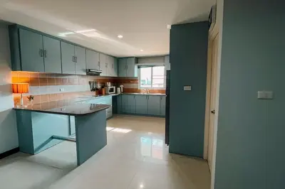 a kitchen with blue cabinets and a table in it at Rawai Palm Beach Квартира 220м in Rawai Beach