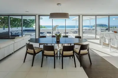 a dining room with a table and chairs at Kata Rocks in Kata Beach