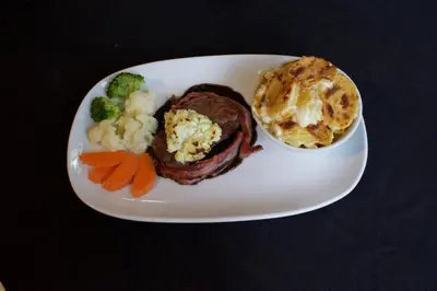 a plate of food with meat and vegetables on a table at Sugar and Spice Inn in Kata Beach