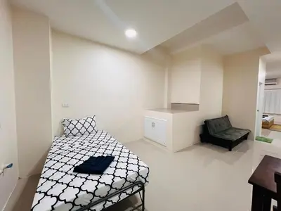a small bedroom with a bed and a chair at Vista Residence Patong in Patong Beach