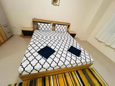 a bed with black and white sheets and blue pillows at Vista Residence Patong in Patong Beach