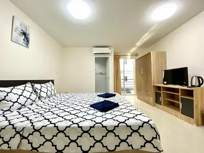 a bedroom with a large bed and a television at Vista Residence Patong in Patong Beach