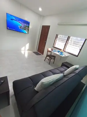 a living room with a couch and a table at Songbird Suites in Ban Khlong Haeng