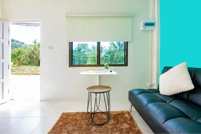 a living room with a couch and a table at Songbird Suites in Ban Khlong Haeng