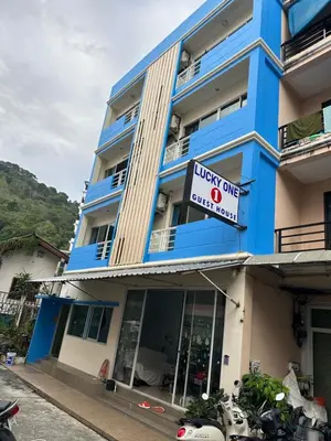 a blue building with a sign that reads lucky one hotel at Lucky One Guesthouse in Patong Beach