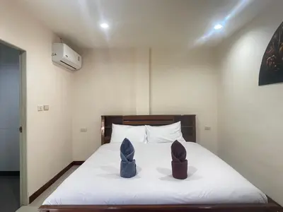 two shoes sitting on a bed in a room at Lucky One Guesthouse in Patong Beach