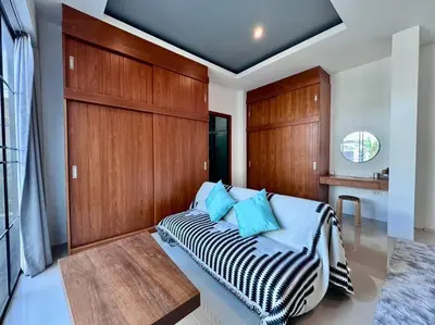 a bedroom with a bed with a wooden wall at Funtime pool villa in Kata Beach