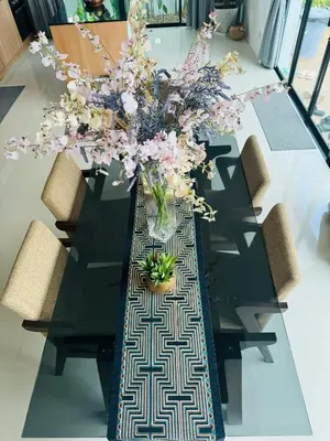 a black table with a vase of flowers on it at Funtime pool villa in Kata Beach