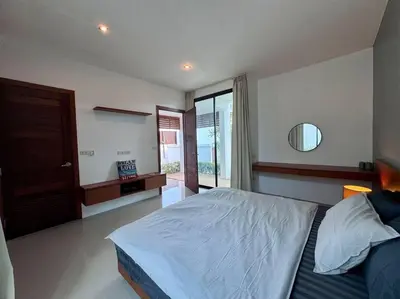 a bedroom with a large bed and a mirror at Funtime pool villa in Kata Beach