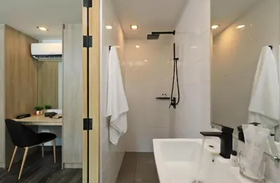 a bathroom with a sink and a toilet and a desk at Duplex Condo pool access in Rawai Beach