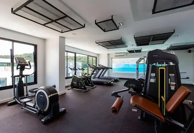 a gym with several treadmills and exercise bikes in it at Duplex Condo pool access in Rawai Beach