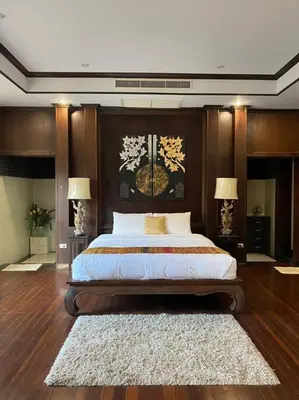 a bedroom with a large bed and two lamps at Vela House Phuket in Changwat Phuket