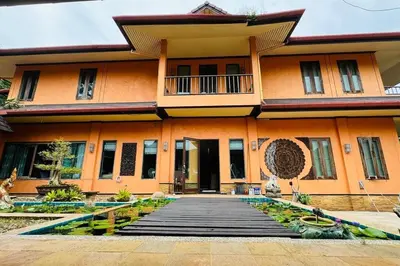 an orange building with a walkway in front of it at Vela House Phuket in Changwat Phuket