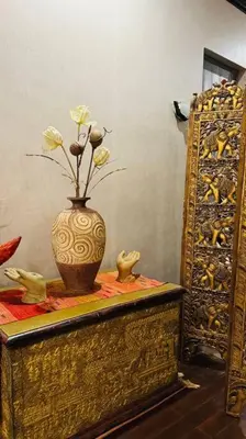 a vase with flowers in it on a table at Vela House Phuket in Changwat Phuket