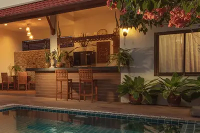 a house with a swimming pool and a bar at Villa on Panwa with 2 house keepers in Ban Bo Rae