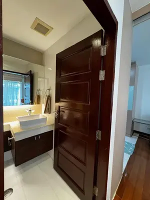 a bathroom with a sink and a wooden door at DREAMS APARTMENTS by ART PATONG RESIDENCE in Patong Beach