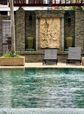 two benches sitting next to a pool of water at DREAMS APARTMENTS by ART PATONG RESIDENCE in Patong Beach