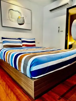 a bed with a wooden frame in a bedroom at DREAMS APARTMENTS by ART PATONG RESIDENCE in Patong Beach