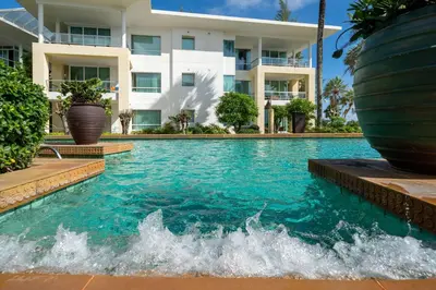 a swimming pool in front of a building at Karon Seaview Beachfront - 2 BR Apartment At Paradox Residence in Karon Beach