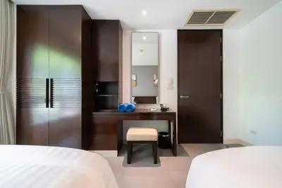 a bedroom with a desk and a sink and a mirror at Karon Seaview Beachfront - 2 BR Apartment At Paradox Residence in Karon Beach