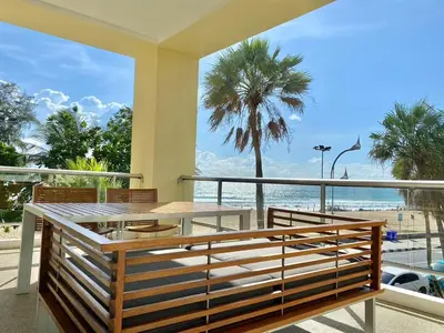 a table and chairs on a balcony with a view of the beach at Karon Seaview Beachfront - 2 BR Apartment At Paradox Residence in Karon Beach