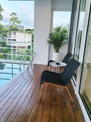 a balcony with a chair and a table and a window at little princess \u5c0f\u516c\u4e3b\u522b\u5885 in Patong Beach
