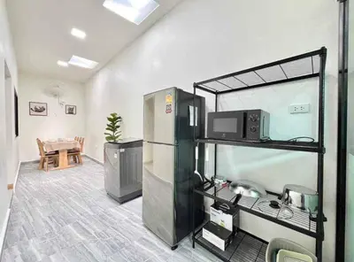 a room with a room with a refrigerator and a table at Mali Villa in Ban Suan