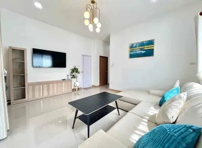 a living room with a couch and a table at Mali Villa in Ban Suan