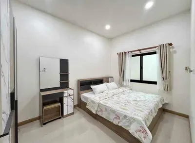a small bedroom with a bed and a window at Mali Villa in Ban Suan