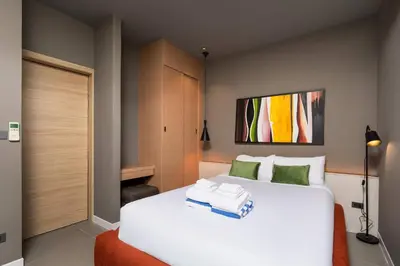 a bedroom with a large white bed with green pillows at Solano Tropical 3BR Pool Villa at Bang Tao in Layan Beach