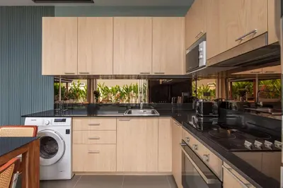 a kitchen with wooden cabinets and a washer and dryer at Solano Tropical 3BR Pool Villa at Bang Tao in Layan Beach
