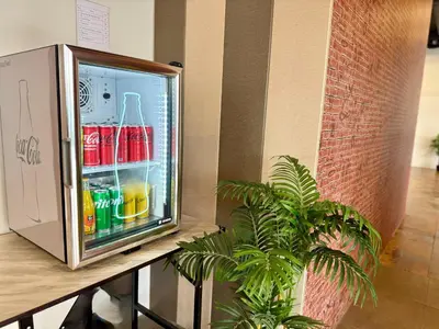 an open refrigerator with drinks in it next to a plant at Diva Boutique Hotel in Patong Beach