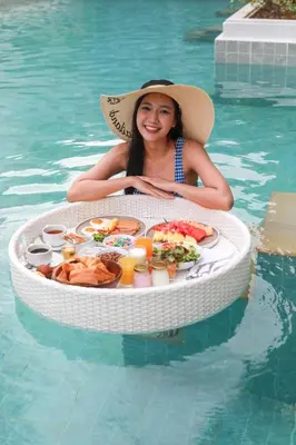 a woman sitting in a pool in a circle of food at Lalynn Resort & Villas, Phuket in Thalang