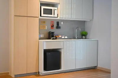 a kitchen with white cabinets and a microwave at Lalynn Resort & Villas, Phuket in Thalang