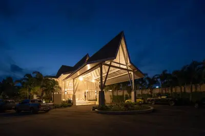 a building with a triangular roof at night at Lalynn Resort & Villas, Phuket in Thalang