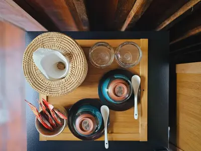 a wooden box with plates and bowls and utensils at Cheewatra Farmstay Phuket ชีวาตรา ฟาร์มสเตย์ ภูเก็ต in Thalang