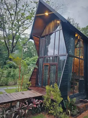 a house with a large window and a wooden deck at Cheewatra Farmstay Phuket ชีวาตรา ฟาร์มสเตย์ ภูเก็ต in Thalang