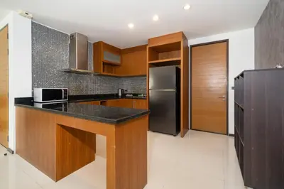 a kitchen with a black counter top and a refrigerator at The fin villa rawai 2 bedroom in Ban Saiyuan (1)
