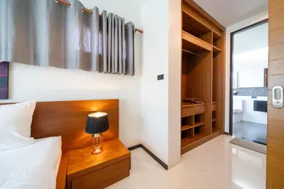 a bedroom with a bed and a table with a lamp at The fin villa rawai 2 bedroom in Ban Saiyuan (1)