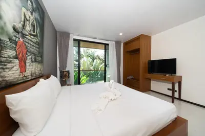 a bedroom with a white bed and a television at The fin villa rawai 2 bedroom in Ban Saiyuan (1)